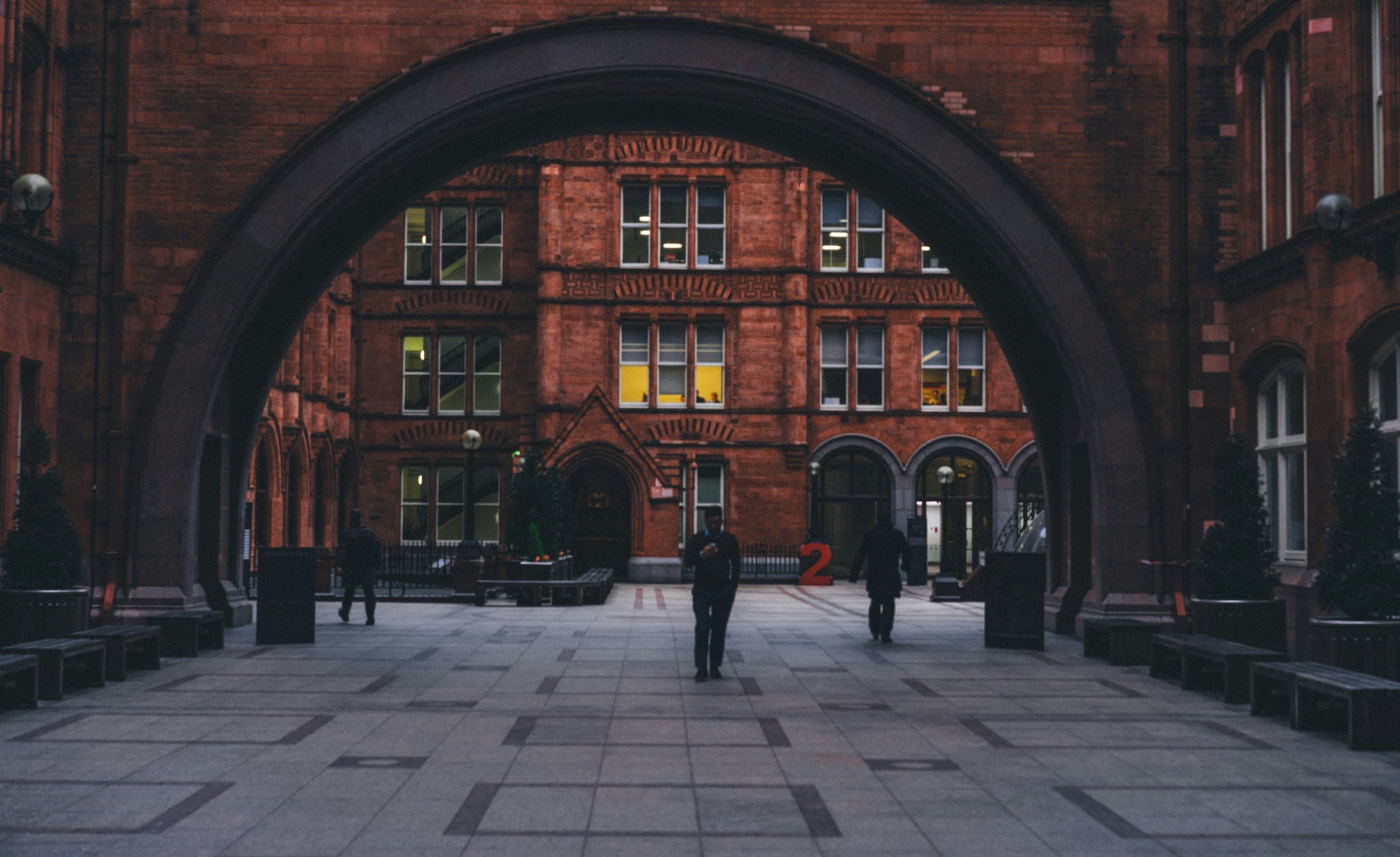 Students walking beneath a university archway