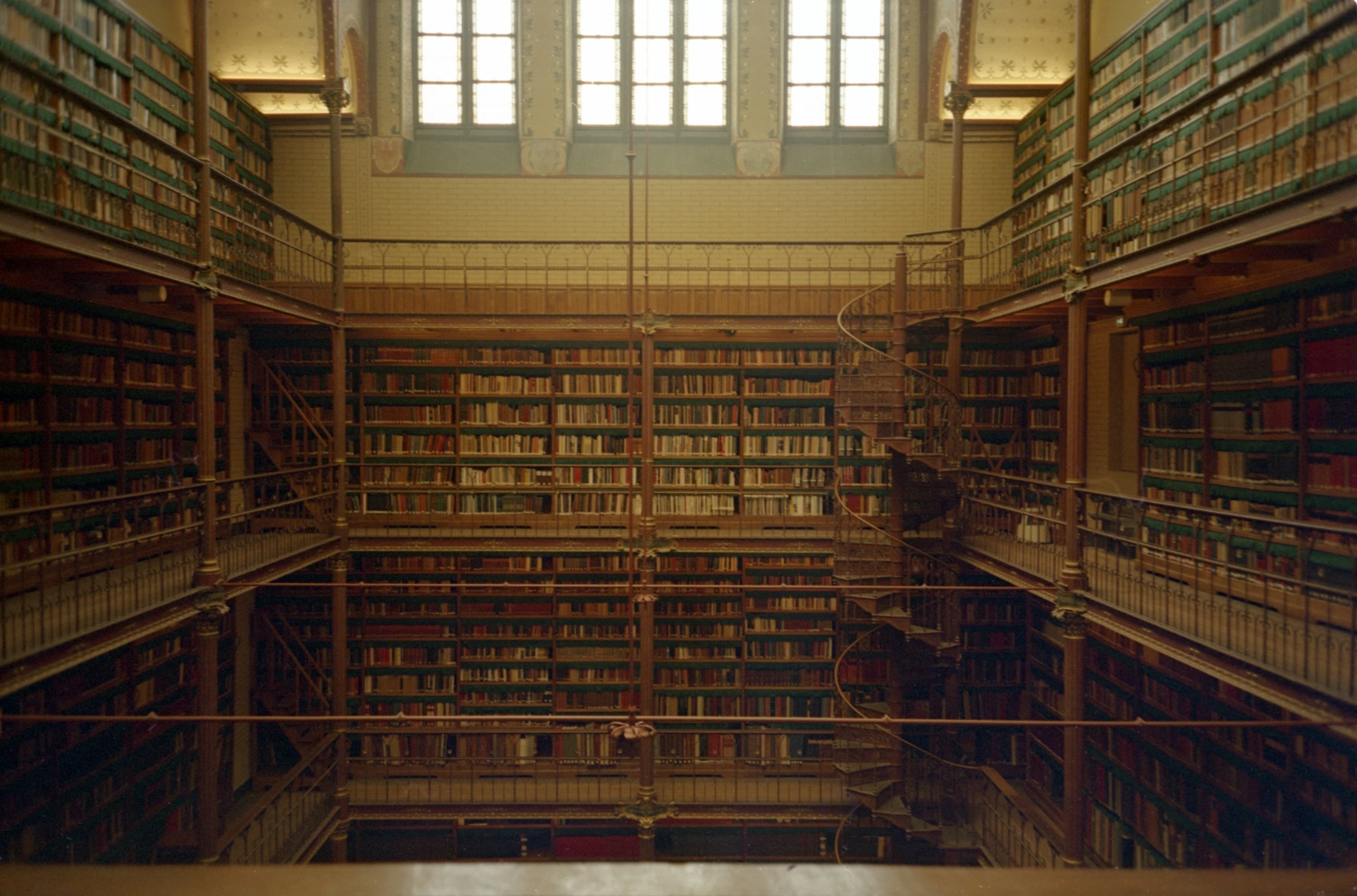 Multi-level library with wooden bookshelves and a spiral staircase