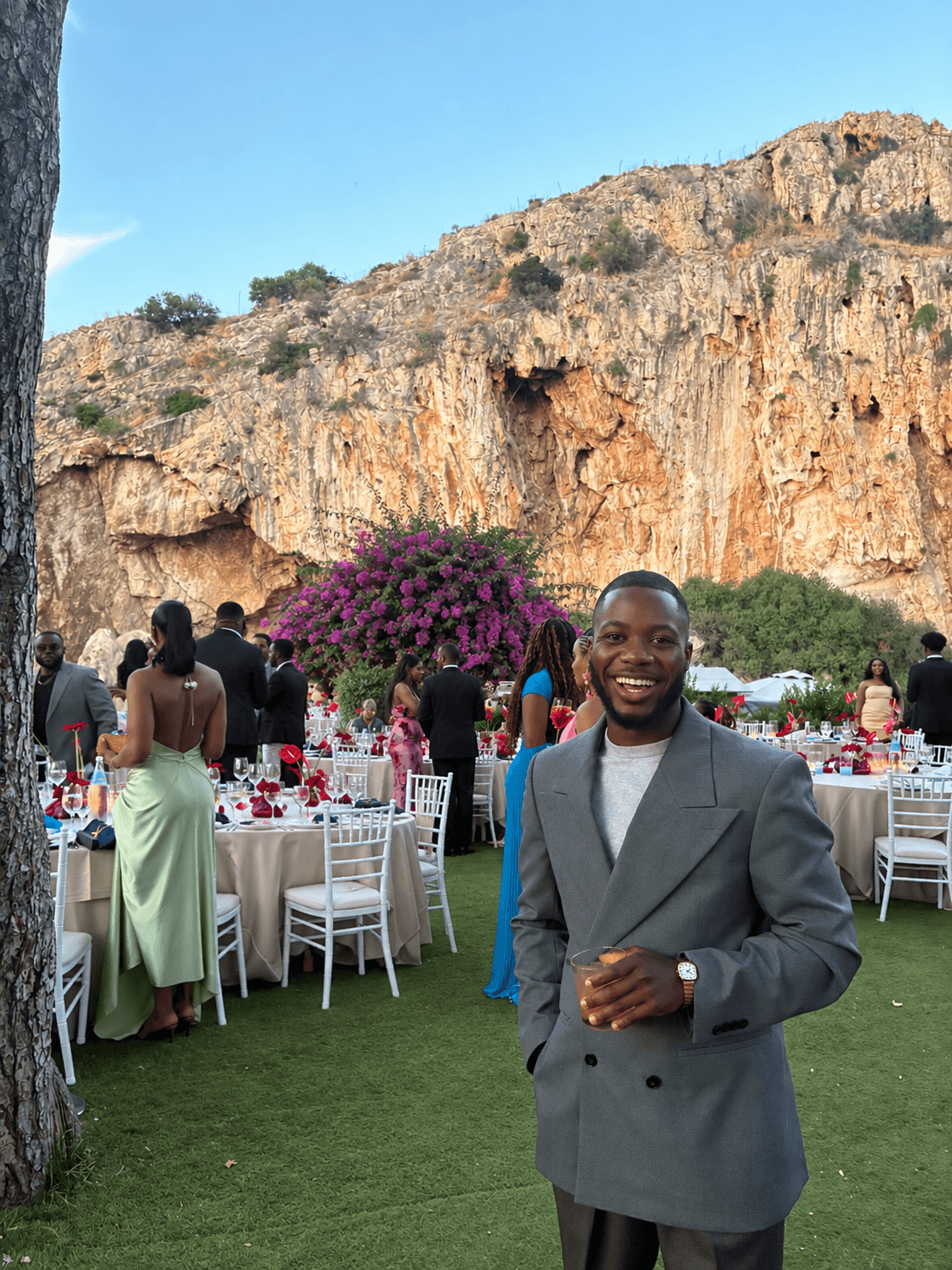 Abdullah Fadare smiling in a grey suit at an outdoor event